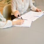 Image of two women reviewing paperwork, representing how The Law Offices of Susan A. Rodriguez, APC can help you navigate the new CFRA leave requirements.
